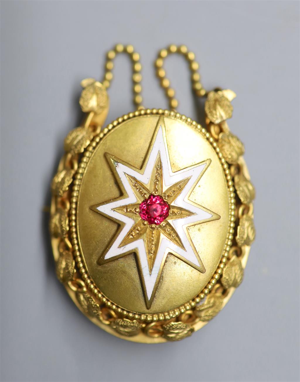 A Victorian gilt metal, white enamel and red paste set oval mourning brooch, with chain swags, 55mm